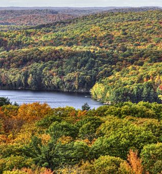 Blick von oben über die bunt verfärbten Wälder mit See des Algonquin Provincial Park
