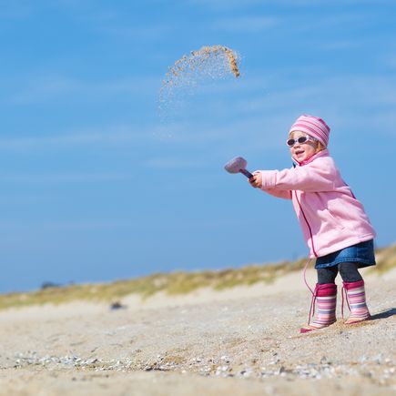 Maedchen spielt am Strand