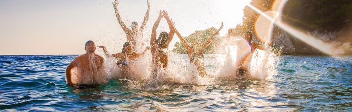 Eine Gruppe von Menschen, die im Meer planscht.