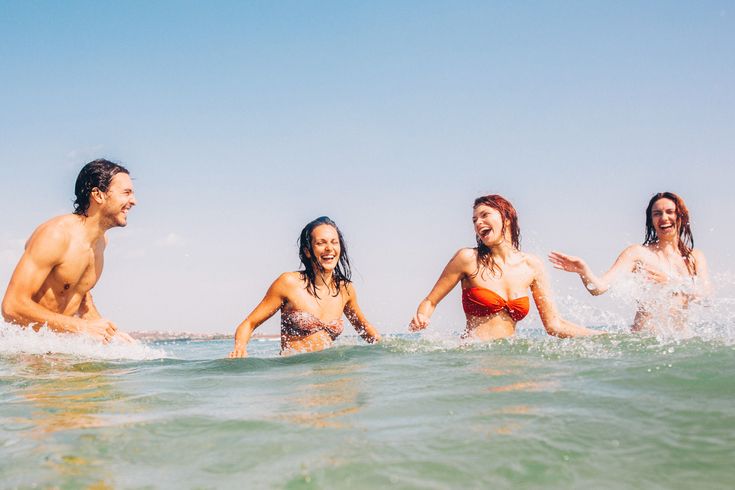 Vier Personen schwimmen im Meer.