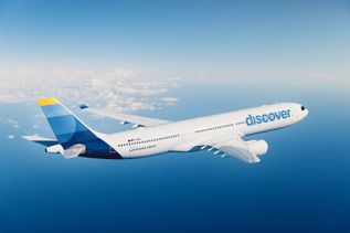 Discover Airlines Flugzeug in luftiger Höhe über dem Atlantik bei Tageslicht. 