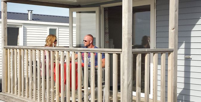 Tiny House mit Familie auf der Terrasse