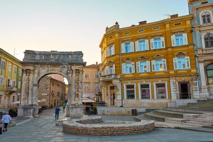 Ein Stadtplatz in Pula, Kroatien, mit historischen Gebäuden.