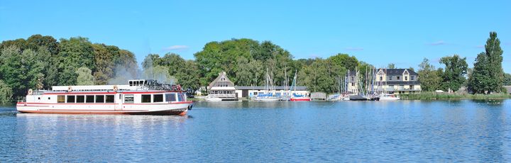 Eine Promenade am Müritzsee in Röbel mit Booten und Gebäuden am Ufer.