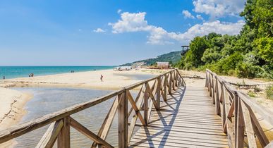 Steg am Strand von Albena in Bulgarien mit blauem Himmel im Hintergrund.