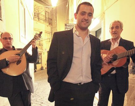 Drei Männer spielen Gitarre und singen in einem Restaurant.