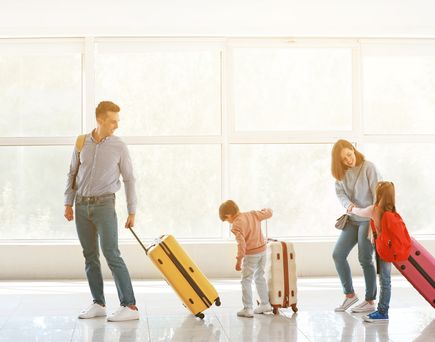 FAmilie mit Koffer am Flughafen