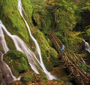 Ein Wasserfall, der in mehrere Stufen über Felsen fließt.