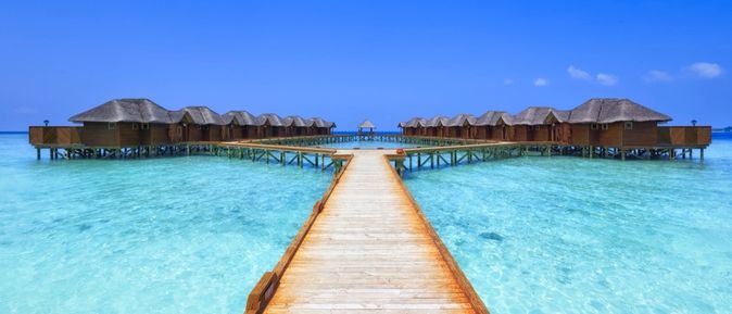 Überwasser-Bungalows mit einem Steg.