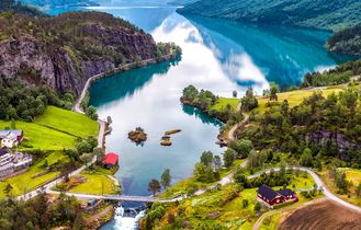 Eine Luftaufnahme einer gewundenen Bergstraße, die sich durch grüne Vegetation und einen Fluss schlängelt.