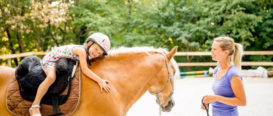 Familienurlaub Cluburlaub Kind lernt Reiten auf einem Pferd