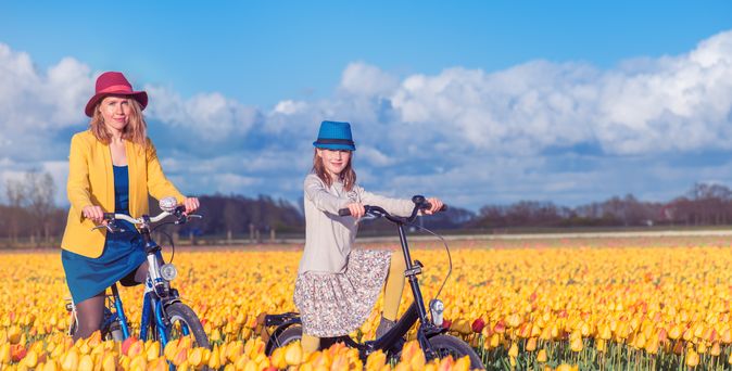 Mutter und Kind mit Fahrrad im Tulpenfeld