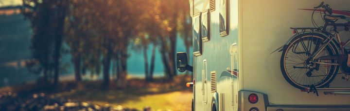 Ein Wohnmobil auf einer Straße bei Sonnenuntergang.
