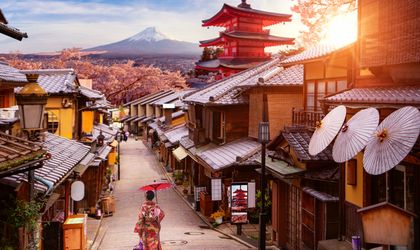 Dorf in Japan, FRau läuft mit Schirm durch die Gasse
