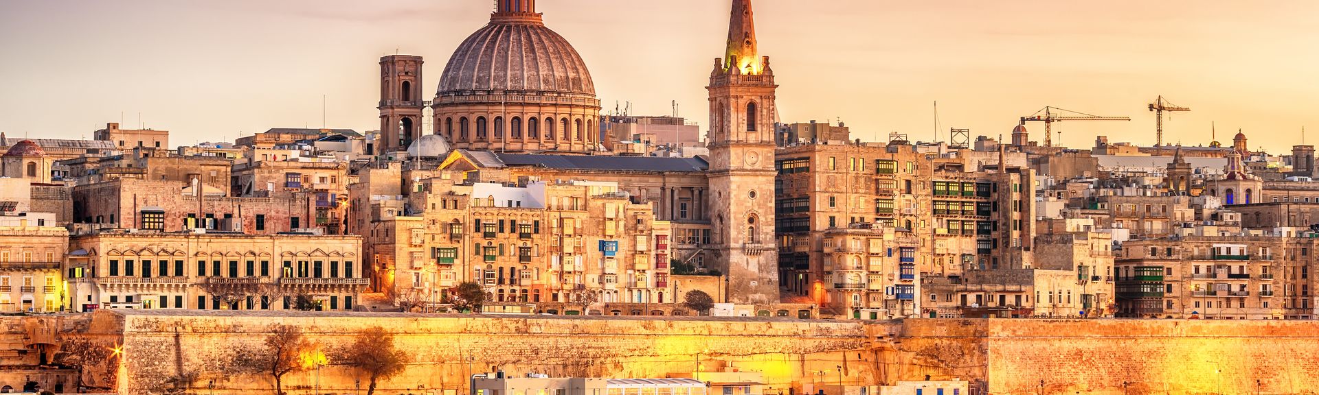 Valletta, Malta: skyline from Marsans Harbour at sunset. The cathedral