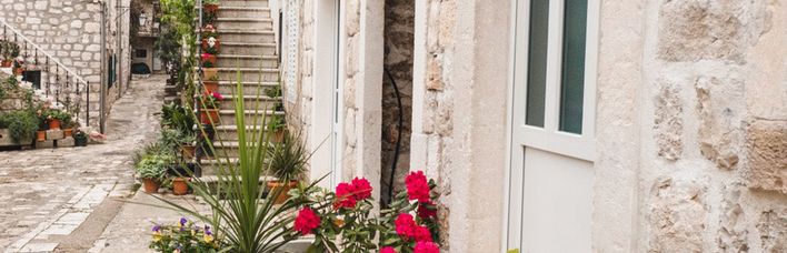 Ein Balkon mit Blumen vor einem alten Gebäude.