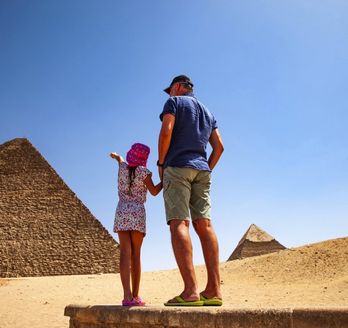 Vater und Tochter vor einer Pyramide