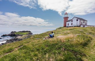 Ferryland Leuchtturm auf Berg mit 2 Picknickern auf der Wiese