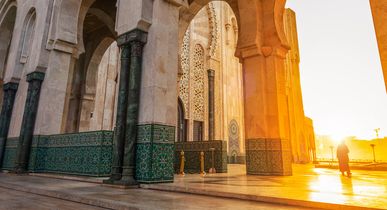Eine Moschee mit einem hohen Minarett bei Sonnenuntergang.
