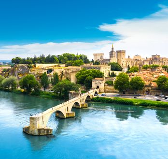Blick aus der Vogelperspektive auf Avignon mit seinen alten Gemäuern und einem Steg.