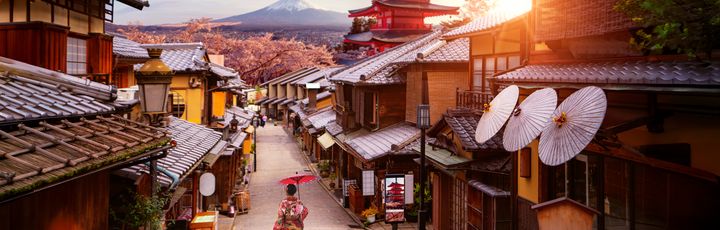 Dorf in Japan, FRau läuft mit Schirm durch die Gasse