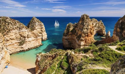 Die beeindruckenden Klippen von Benagil an der Algarveküste, Portugal, mit ihren bizarren Felsformationen und Höhlen, die von türkisfarbenem Wasser umspült werden.