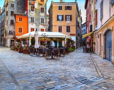 Ein Café in Rovinj mit Tischen und Stühlen.
