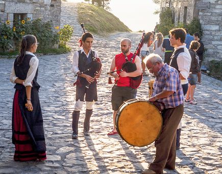 Zwei Frauen in traditioneller Kleidung gehen eine Straße mit alten Gebäuden entlang.