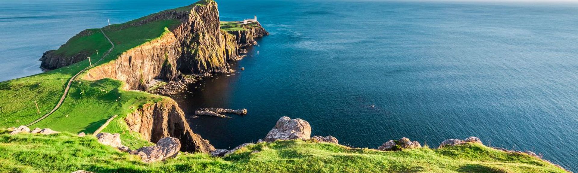 Küste mit hellgrünem Meer und mit weißem Strand in Schottland 