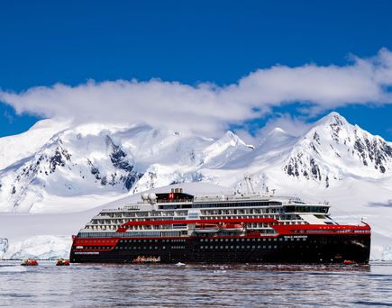 Kreuzfahrtschiff vor einem Eisberg