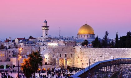 Die Klagemauer in Jerusalem, Israel, mit der beleuchteten Kuppel des Felsendoms im Hintergrund.