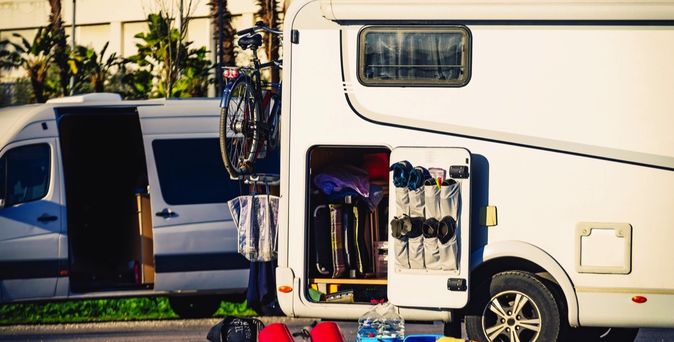 Seitenansicht eines geöffneten Wohnmobils, das für Wartungsarbeiten bereitsteht.