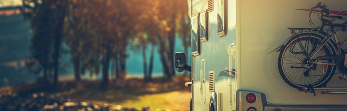 Ein Wohnmobil auf einer Straße bei Sonnenuntergang.