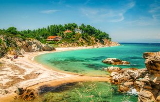 Eine Bucht mit türkisblauem Wasser und einem Strand.