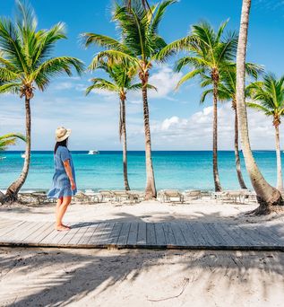 Frau läuft auf einem Holzsteg am Strand