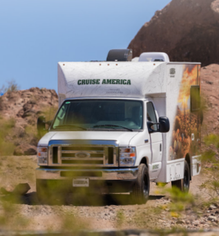 Der neue C 18 Camper von Cruise America steht in einer felsigen braunen Landschaft bei Sonnenschein