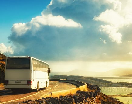 Ein Camper oder Van steht in einer Landschaft mit Blick auf das Meer.