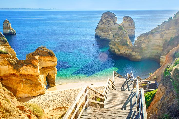 Eine felsige Küstenlandschaft mit natürlichen Brücken und türkisfarbenem Wasser.