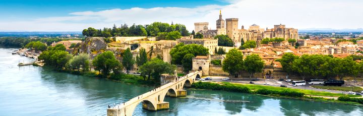 Blick aus der Vogelperspektive auf Avignon mit seinen alten Gemäuern und einem Steg.