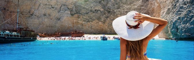 Frau auf einem Boot geniesst den Ausblick auf den Strand Navagio