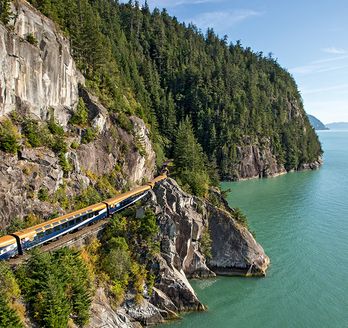 Der Rockymoutaineer fährt entlang der kanadischen Berge umgeben von Wasser