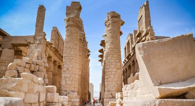 Eine archäologische Stätte in Luxor, die von einer großen Säulenreihe und alten Strukturen umgeben ist.