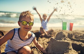 Kind baut eine Sandburg am Strand