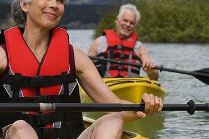 Zwei Personen in Kajaks auf einem See.