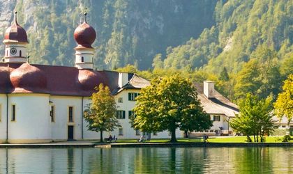 Ein See mit Bäumen und Bergen.
