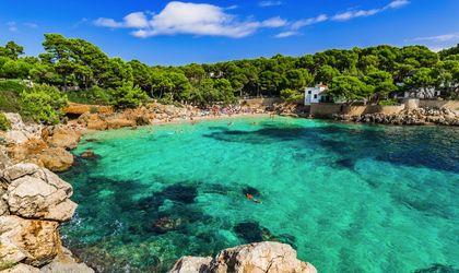 Eine Bucht mit türkisfarbenem Wasser und einem Sandstrand.