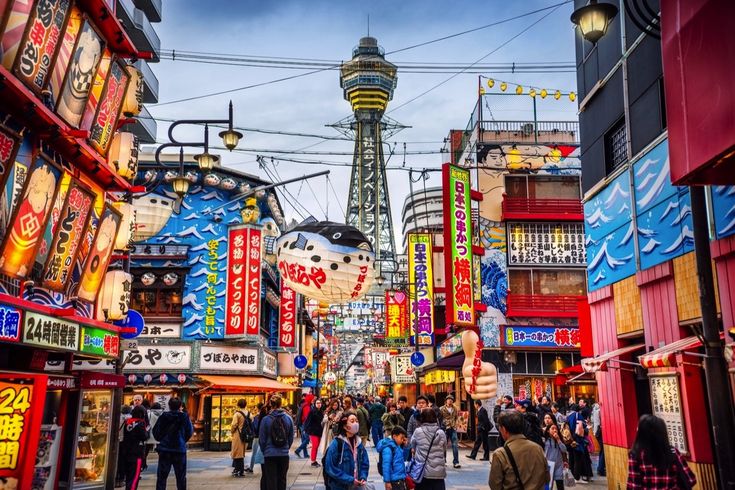 Belebte Einkaufsstraße in Osaka mit bunten Leuchtreklamen – Zwischen grellen Leuchtreklamen und traditioneller Küche pulsiert das Leben in Osakas Vergnügungsviertel.
