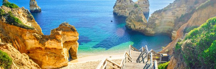 Eine felsige Küstenlandschaft mit natürlichen Brücken und türkisfarbenem Wasser.