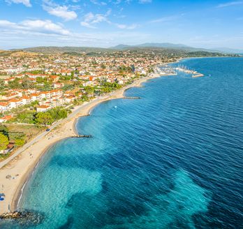 Blick auf Nikiti aus der Vogelperspektive. Strand, grüne Vegetation und einige Häuser.