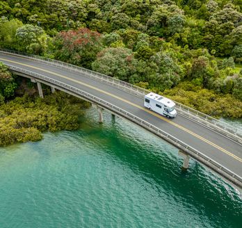 Camper fährt über eine Brücke in Neuseeland